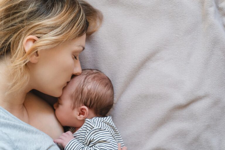 Mother lovingly breastfeeding her newborn baby, highlighting the bond and nourishment during National Breastfeeding Month.