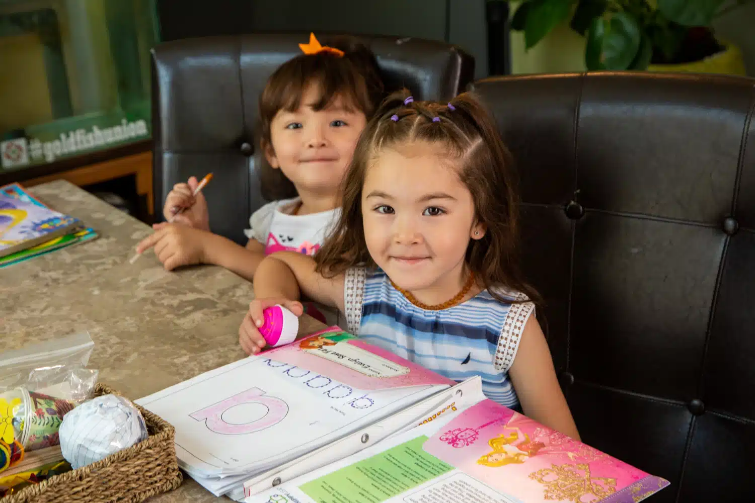 two girls sitting down to work on homework