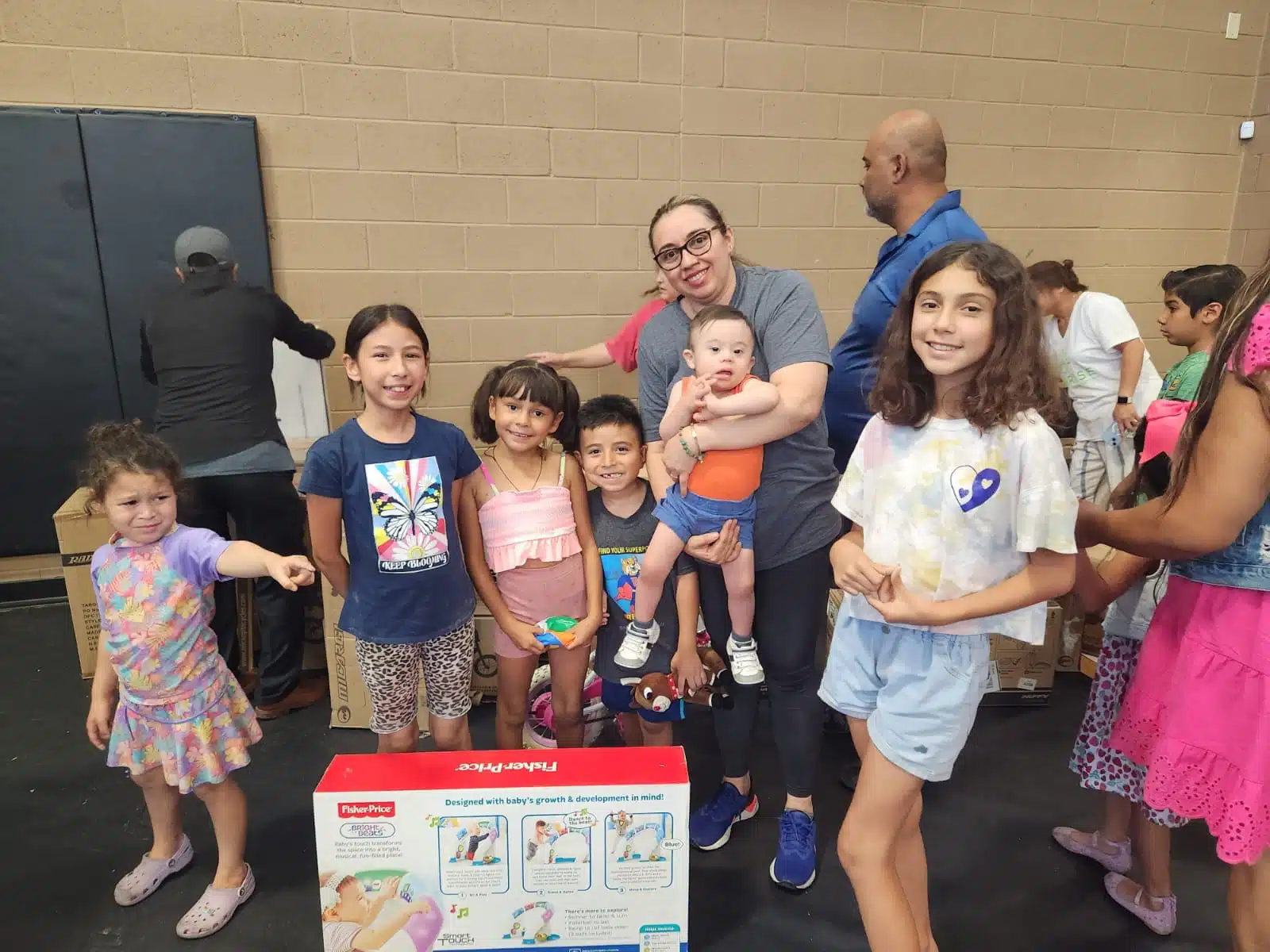 A group of happy children and a early childhood education teacher at Sunrise Children's Foundation event, representing the community support behind Early Childhood Education Careers FAQ.