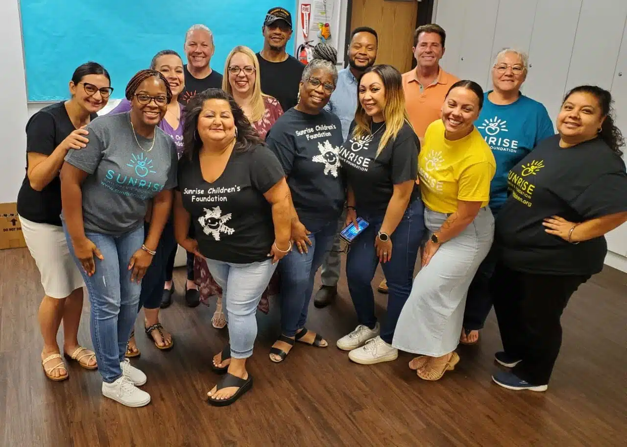 A group of diverse educators and staff from Sunrise Children's Foundation gathered for a team photo, showcasing the supportive community behind Early Childhood Education Careers FAQ.