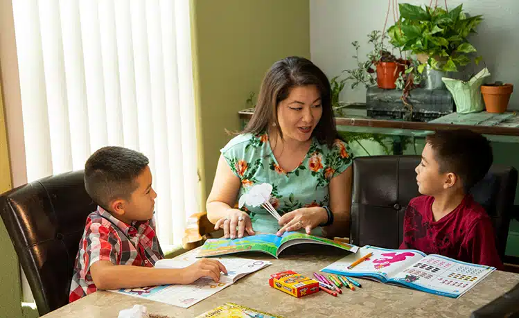 Educator engaging with children through reading and activities, showcasing the importance of early childhood education programs in fostering learning.