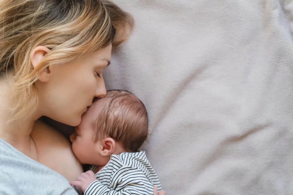 Mother lovingly breastfeeding her newborn baby, highlighting the bond and nourishment during National Breastfeeding Month.