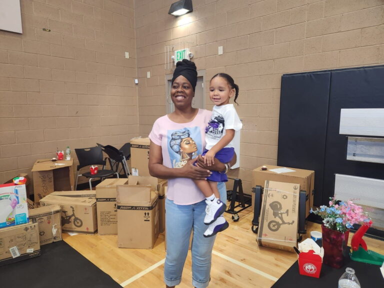 A mother holding her daughter at a Sunrise Children’s Foundation event.